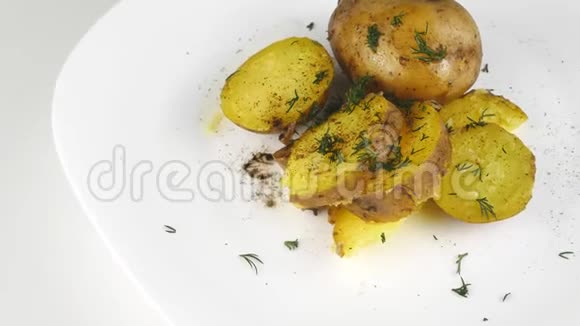 土豆在皮肤上在白色的盘子上旋转做家常菜视频的预览图
