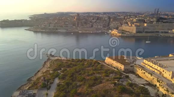 马耳他瓦莱塔日出时在马诺河岛上空飞行4K背景是瓦莱塔古老的城墙视频的预览图