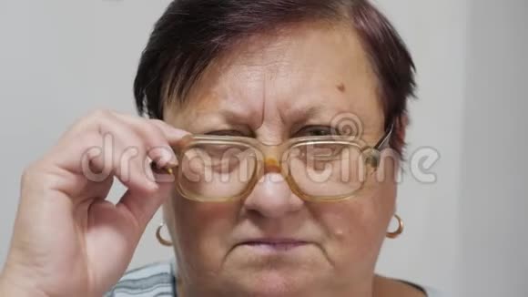 一位老年妇女摘下眼镜眼睛有问题视频的预览图
