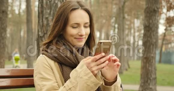 迷人的女孩手机滚动和触摸屏打字同时在网上社交穿着棕色疤痕视频的预览图