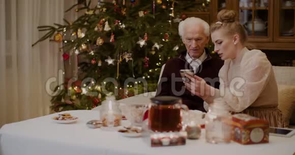 在圣诞节教祖父使用手机的女人视频的预览图