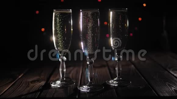 三个黑色背景的香槟杯有多种颜色的闪光灯视频的预览图
