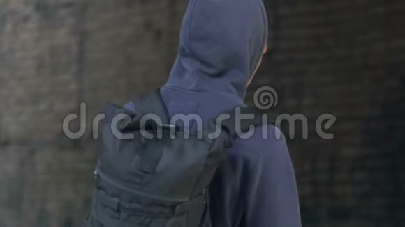 带着头巾受伤的年轻人带着背包在废弃的建筑里行走问题视频的预览图