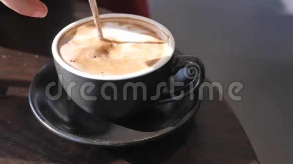 年轻女子用勺子搅拌一杯咖啡视频的预览图