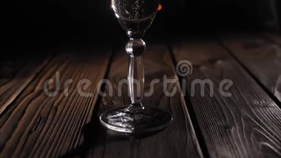 在黑色背景上用闪烁的灯光特写一杯香槟视频的预览图