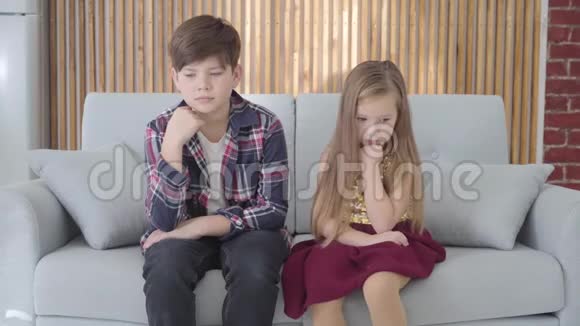 恶心的白种人女孩坐在沙发上英俊的小男孩抚摸她的长发朋友照顾可爱的女士视频的预览图
