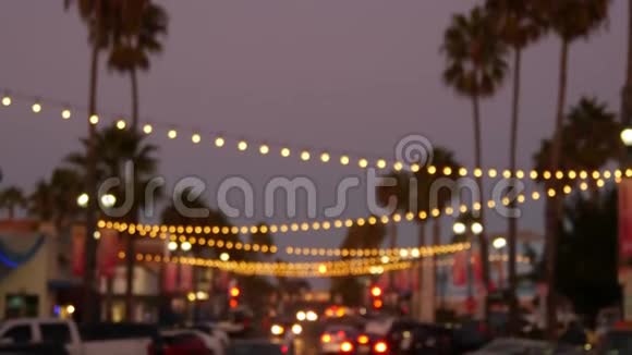 装饰凝视花环灯光棕榈树剪影夜空背景模糊装饰着灯的街道视频的预览图