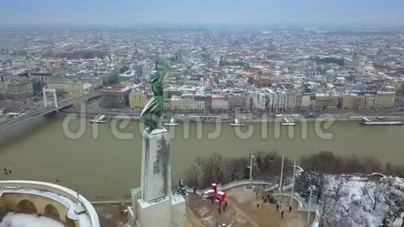 匈牙利布达佩斯4K无人驾驶飞机的镜头关于无人驾驶飞机在一个下雪的冬天在自由女神像周围飞行视频的预览图