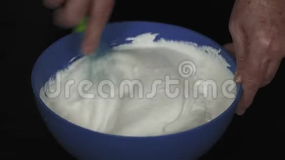 特写镜头老年妇女用手搅拌机为蛋糕准备的鞭子霜视频的预览图