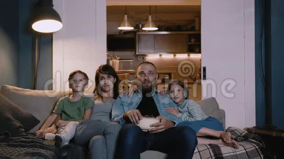 幸福年轻的高加索家庭的时间推移肖像两个孩子在家里沙发上看电影一起聊天视频的预览图