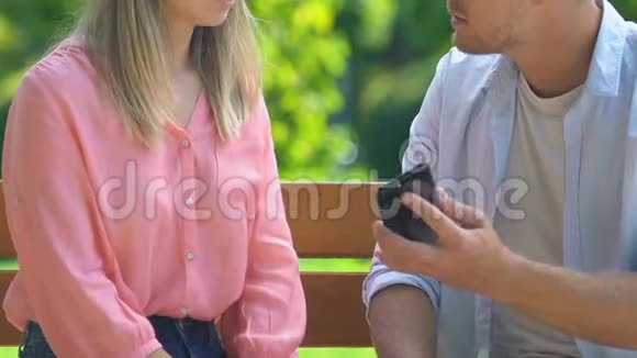 嫉妒的男朋友拿着女孩的智能手机和争吵不信任和危机视频的预览图