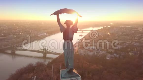匈牙利布达佩斯日出时无人驾驶飞机围绕自由女神像上空飞行的4K空中镜头视频的预览图