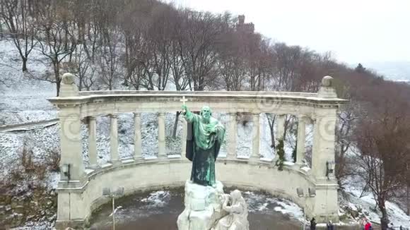 匈牙利布达佩斯4K无人驾驶飞机在大雪纷飞的冬日从圣盖勒特主教雕像和纪念碑上空飞过视频的预览图