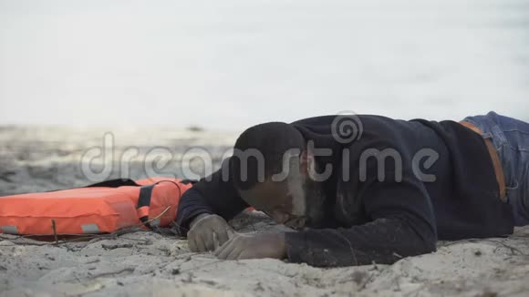 痛苦的人躺在救生衣附近在海难后寻求帮助视频的预览图