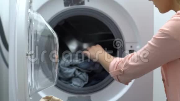从洗衣机里洗衣服的年轻女人家务家务视频的预览图