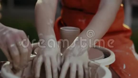 特写镜头女孩把手放在碗里用水和陶圈的粘土一起工作视频的预览图