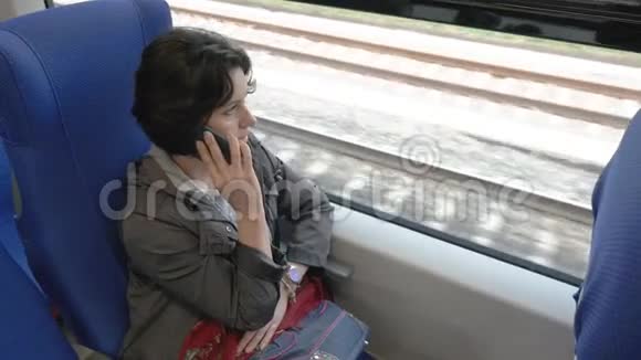 一个女人坐在火车上从上面看电话侧景视频的预览图