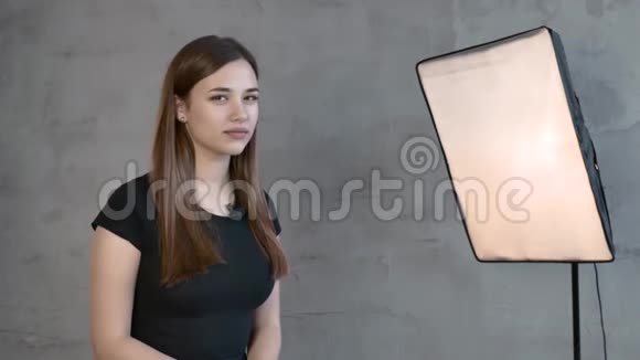 白人迷人的棕色头发女孩靠在灰色的墙上说话在镜头上视频的预览图