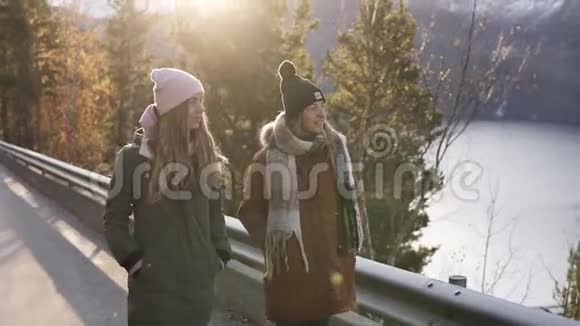 两个穿着冬装的女游客在穿过乡间的一条长长的路上缓慢地走着朝雪的方向走去视频的预览图