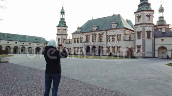女游客在广场上拍了一张国王宫殿的照片视频的预览图