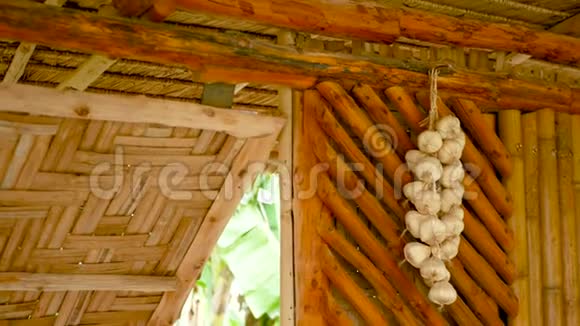 墙上有一串大蒜挂在亚洲传统民居竹墙上的一束干蒜视频的预览图