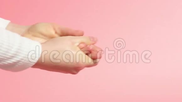 女孩用粉红色背景的肥皂特写洗手视频的预览图