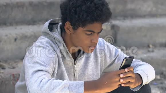 悲伤的美国青少年滚动智能手机感到紧张尴尬的年龄问题视频的预览图