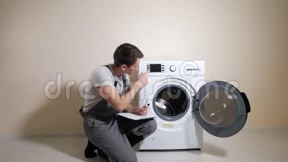 工人检查破洗衣机并在室内做记录视频的预览图