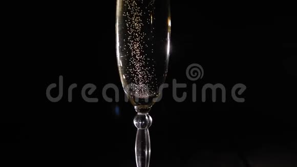 一杯香槟的特写镜头在黑色背景下旋转视频的预览图