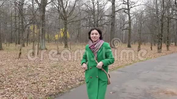 中年白种人妇女走在公园前景的小路上慢动作视频的预览图