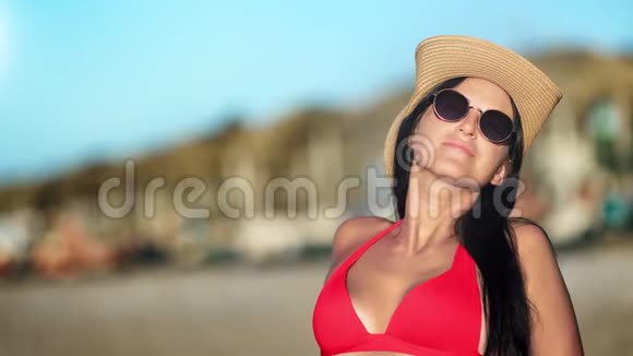 迷人的晒黑时尚女孩比基尼放松享受日光浴在海滩中等特写视频的预览图