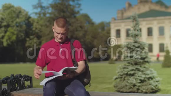 忙碌的男学生坐在长凳上接电话视频的预览图