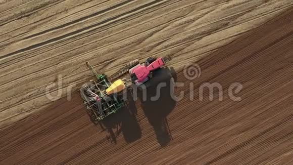 农田空中俯视图中种植粮食作物的拖拉机视频的预览图