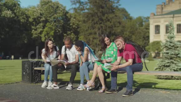 多民族学生在公园长椅上聚会视频的预览图