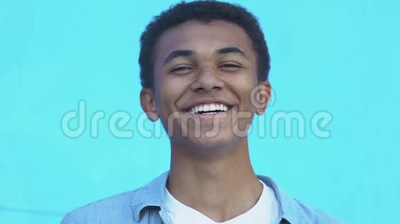 积极的非裔美国少年在蓝底镜头下笑视频的预览图