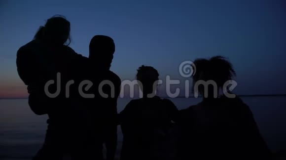 夜海背景下的家庭拥抱剪影困难中的团结视频的预览图