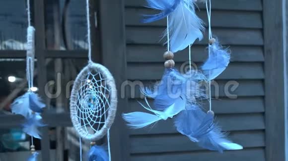 蓝色的捕梦者羽毛挂在木屋前慢慢移动漂浮着印度传统的护身符视频的预览图