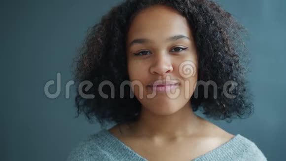 美国黑人妇女在深灰色背景下微笑的肖像视频的预览图