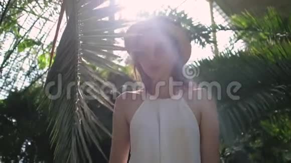 棕榈树附近温室里的亚洲女人视频的预览图