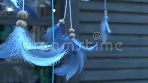蓝色装饰羽毛的捕梦器挂在木屋前慢慢移动漂浮传统视频的预览图