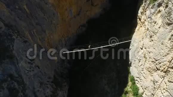 游客们在山上的吊桥上散步徒步旅行和通过费拉塔航空视频的预览图