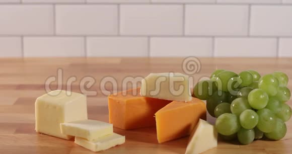 手把一片片绿色放在奶酪小吃托盘上然后从茎上摘一颗绿色葡萄视频的预览图