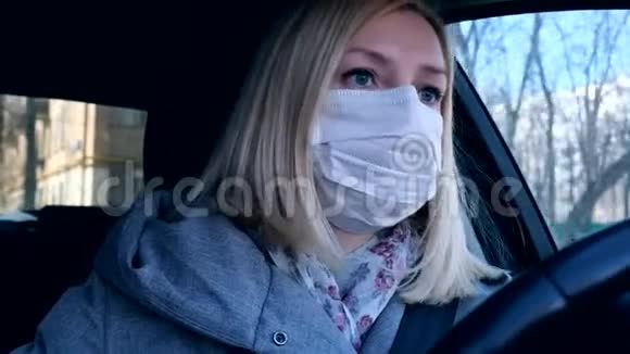 高加索欧洲妇女驾驶一辆汽车戴着白色外科医疗面罩作为预防冠状病毒和视频的预览图
