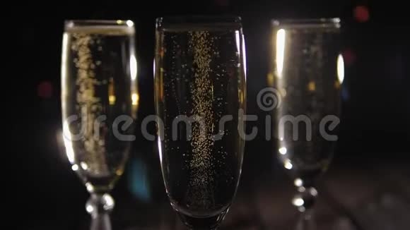 三个黑色背景的香槟杯有多种颜色的闪光灯视频的预览图