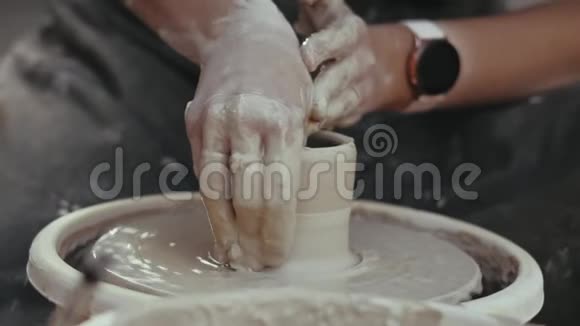 旋转陶圈泥坑女陶工的特写手视频的预览图