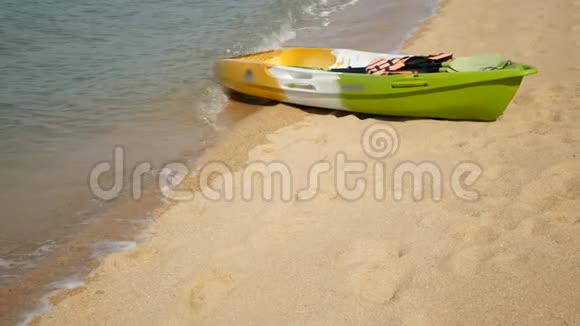 用桨划在沙滩上的皮艇被蓝色的海水冲刷五颜六色的独木舟在波浪状的水晶水中热带寂寞视频的预览图