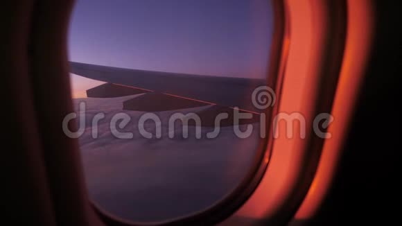 一架飞机从窗户飞过日落天空的云层视频的预览图