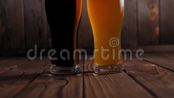 在木制背景上特写两杯啤酒深色啤酒和淡啤酒视频的预览图