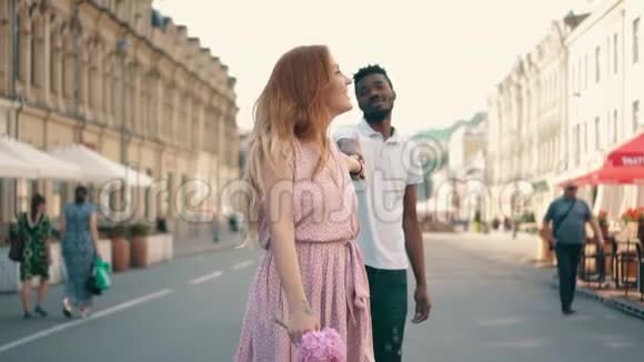 年轻快乐的女人牵着她男朋友手沿着城市街道走视频的预览图