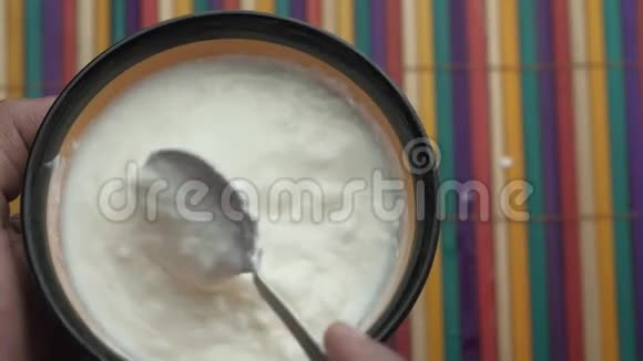 希腊酸奶在一个木制的碗在一个乡村木制的桌子上视频的预览图